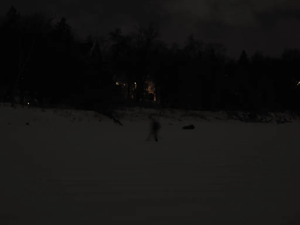 a person crossing a frozen river at night