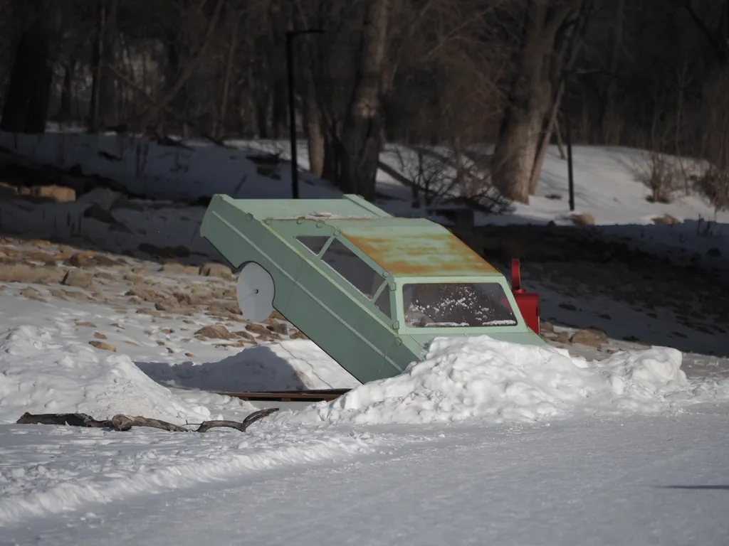 a warming hut shaped like a crashed car