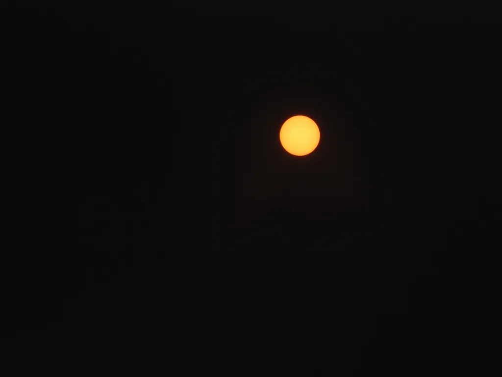 a yellow sun in a black sky