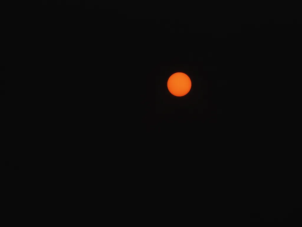 a red sun in a black sky